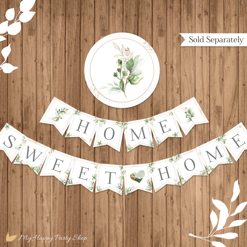 May include: A white banner with green foliage and gold accents reads "Home Sweet Home". The banner is made up of individual flags with each letter on a separate flag. The banner is displayed on a wood background.