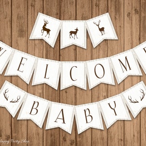 May include: A rustic banner set with the words "WELCOME BABY" in dark brown letters. The banner flags are white with a wood grain texture and brown deer silhouettes. The background is a wooden surface.