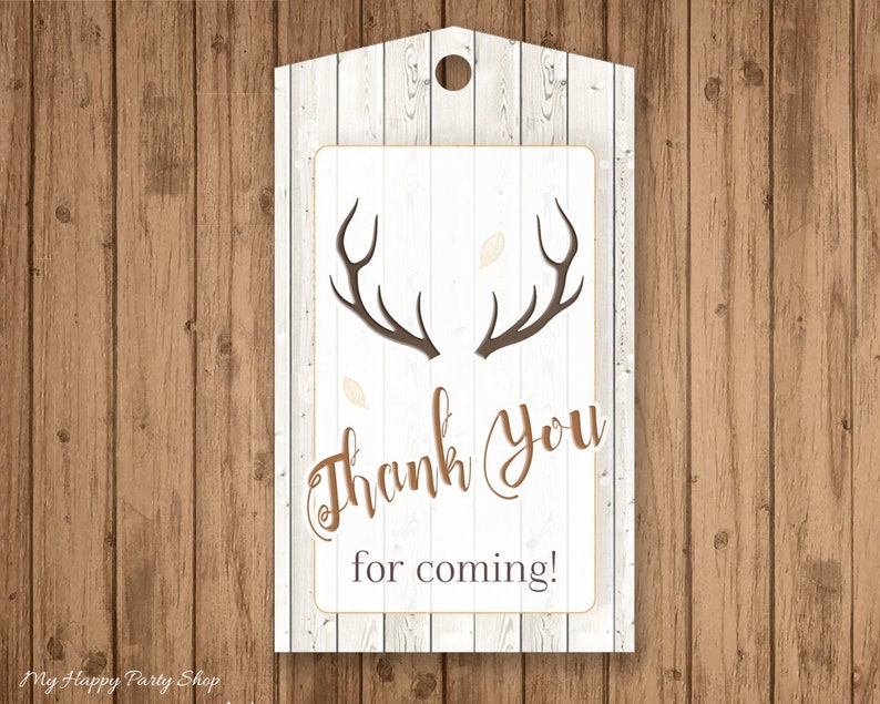 May include: A rustic-themed gift tag with a wooden background. The tag features a white rectangular area with brown antlers and the words "Thank You for coming!" in a decorative font. A small hole is at the top.