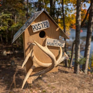 Iowa license plate roof on a cedar birdhouse with real whitetail antlers no hunting sign