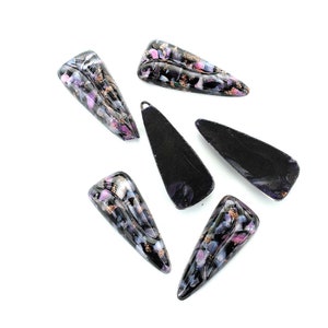 Puede incluir: Seis colgantes de vidrio negro y morado con destellos dorados. Los colgantes tienen forma de lágrima con un extremo puntiagudo.