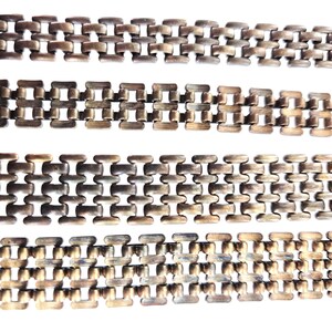 Op de afbeelding: Vier secties antieke metalen kettingen met een herhalend rechthoekig schakelontwerp. De kettingen hebben een aangetaste, bronsachtige uitstraling, met variaties in kleur en textuur. De schakels zijn nauw verbonden, waardoor een doorlopend patroon ontstaat tegen een witte achtergrond.