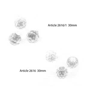 May include: Three clear crystal balls, each measuring 30mm in diameter, are arranged in a cluster. The balls are faceted and reflect light, creating a sparkling effect. The text "Article 2616 30mm" is visible below the balls.