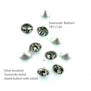 Puede incluir: Botones de vástago de metal cepillado plateado con ojetes. Los botones están adornados con cristales Swarovski verdes. El texto "Swarovski Buttons 1811/120" es visible en la imagen.