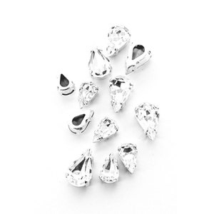 May include: A collection of clear teardrop-shaped rhinestones, ideal for adding sparkle to crafts and jewellery.