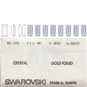 以下が含まれることがあります： 3mm×2mmの金箔を施したクリスタルストーン10グロス入りパッケージのクローズアップ。パッケージには「ART. 4500」と「SWAROVSKI Made in Austria」のラベルが貼られています。
