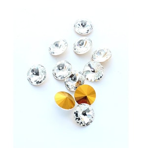 Rivoli 14mm crystal stones made by Preciosa.  The stones are pointed front and back and gold foiled,  Price is for 2 stones.