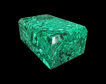 May include: A green malachite box with a decorative, swirling pattern. The box is closed and has a rectangular shape.