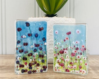 May include: Two glass panels with a blue and white floral design. The panels are rectangular and have a clear glass border. The flowers are in shades of pink, white, and purple.