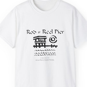 May include: White t-shirt with a black graphic of a pier, sun, and waves. The text "Rod & Reel Pier" is above the graphic, with "ESTABLISHED 1947 Anna Maria Island, Florida" below. A casual, short-sleeved tee.
