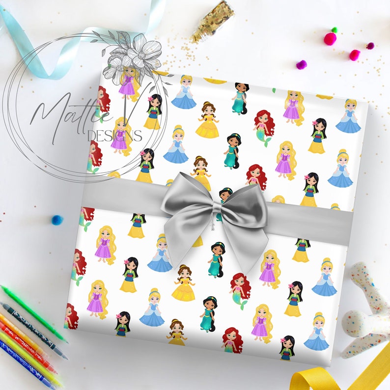 Pu&ograve; includere: Carta da regalo bianca con un motivo ripetitivo di principesse Disney. Le principesse sono vestite con i loro colori caratteristici e sono raffigurate in uno stile cartone animato. La carta &egrave; legata con un nastro argentato.