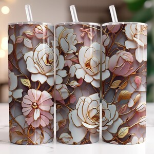 Puede incluir: Tres vasos de acero inoxidable con diseños florales. Los vasos presentan rosas blancas y rosas con detalles dorados sobre un fondo gris. Cada vaso tiene una pajita transparente.