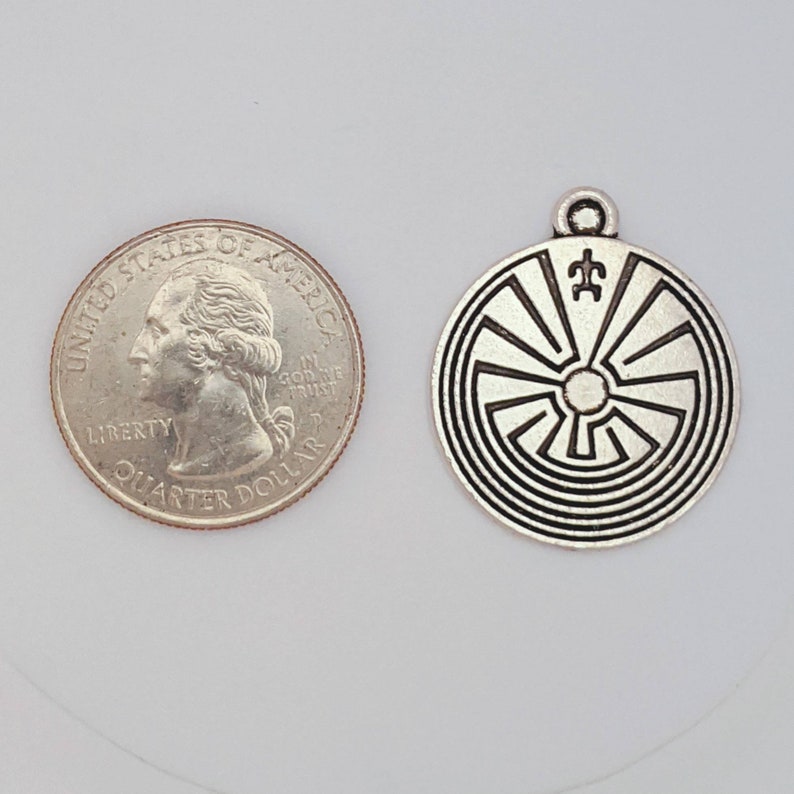 May include: Silver charm pendant featuring a Native American design with a spiral pattern and a symbol in the center. The charm is about the size of a US quarter.