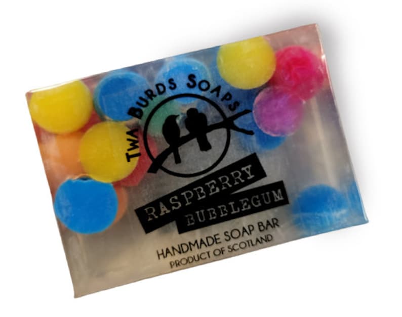 Peut inclure: Un savon transparent parfum&eacute; &agrave; la framboise et au chewing-gum. Le savon est d&eacute;cor&eacute; de p&eacute;pites rondes color&eacute;es et porte l'inscription "Two Birds Soaps" et "Raspberry Bubblegum" en lettres noires. Le savon est fait &agrave; la main en &Eacute;cosse.