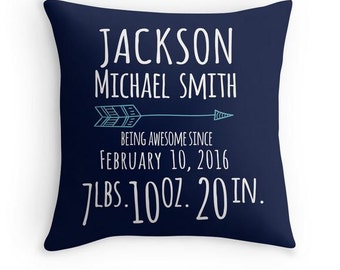 May include: A square navy blue throw pillow featuring white text that reads Jackson Michael Smith, Being Awesome Since February 10, 2016, 7 lbs. 10 oz. 20 in. A light blue arrow graphic with geometric patterns is positioned between the name and date.