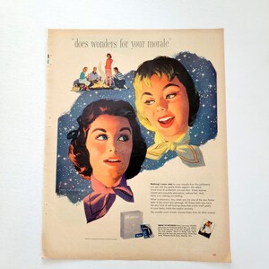 May include: Vintage advertisement featuring two women with stylized hair and scarves, set against a starry background. The text "does wonders for your morale" is at the top. A small box of product is also visible.