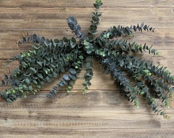 May include: A garland of eucalyptus leaves with a mix of green and dark green leaves.