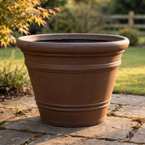 May include: A large, round, brown planter with a wide, thick rim and two horizontal raised bands encircling the body. The container has a tapered shape, narrowing toward the base, and features a smooth, matte finish throughout its exterior surface.