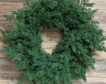 Könnte beinhalten: Ein grüner künstlicher Weihnachtskranz, perfekt zum Dekorieren einer Tür oder Wand während der Weihnachtszeit.