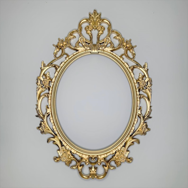 May include: A gold oval-shaped picture frame with ornate details and a decorative design. The frame is made of metal and has a vintage style.
