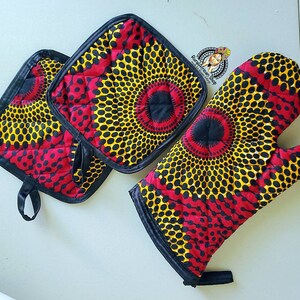 May include: Set of three red, yellow, and black patterned kitchen pot holders. Two are square and one is a mitten style.
