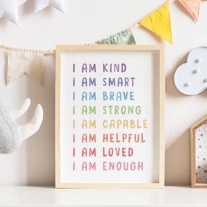 May include: A framed print with a white background and rainbow colored text that reads "I am kind, I am smart, I am brave, I am strong, I am capable, I am helpful, I am loved, I am enough".