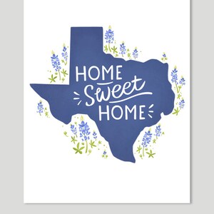 K&ouml;nnte beinhalten: Eine blaue Umrandung des Bundesstaates Texas mit den Worten "Home Sweet Home" in wei&szlig; innerhalb der Umrandung. Die Umrandung ist von Blausternblumen umgeben.