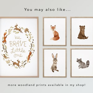 May include: Five framed prints with woodland animal illustrations. The center print features a wreath of woodland animals with the text "be BRAVE little one". The other prints feature a fox, a bear, a rabbit, and a raccoon.