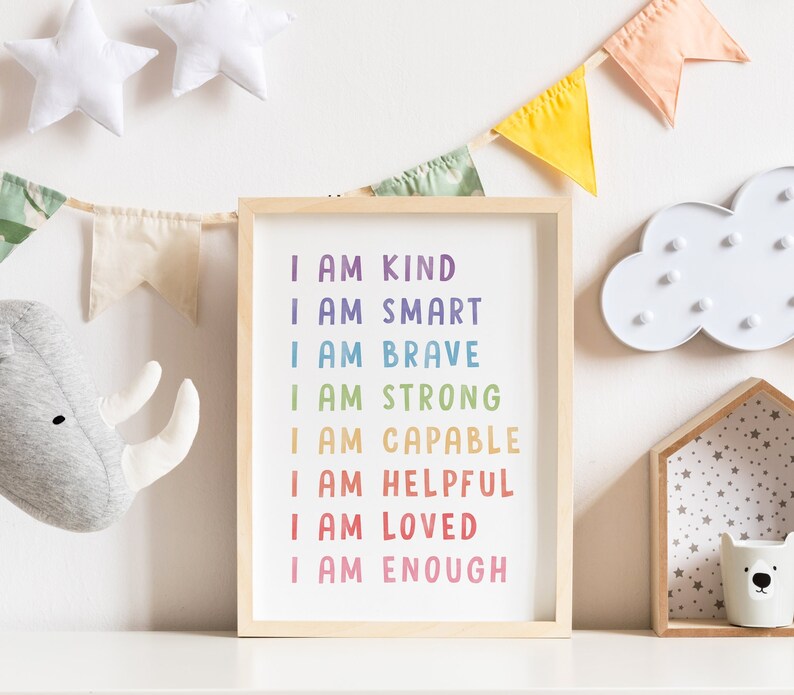 May include: A framed print with a white background and rainbow colored text that reads "I am kind, I am smart, I am brave, I am strong, I am capable, I am helpful, I am loved, I am enough".
