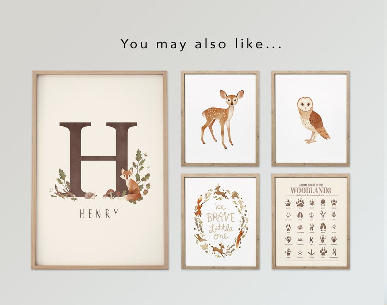 May include: A collection of framed art prints featuring woodland animals and nature-themed illustrations. Includes a print with the letter "H" and the name "HENRY", a deer, an owl, a wreath with text "be BRAVE Little one", and a chart of animal tracks.