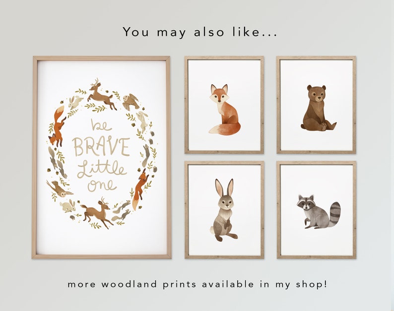 May include: Five framed prints with woodland animal illustrations. The center print features a wreath of woodland animals with the text "be BRAVE little one". The other prints feature a fox, a bear, a rabbit, and a raccoon.
