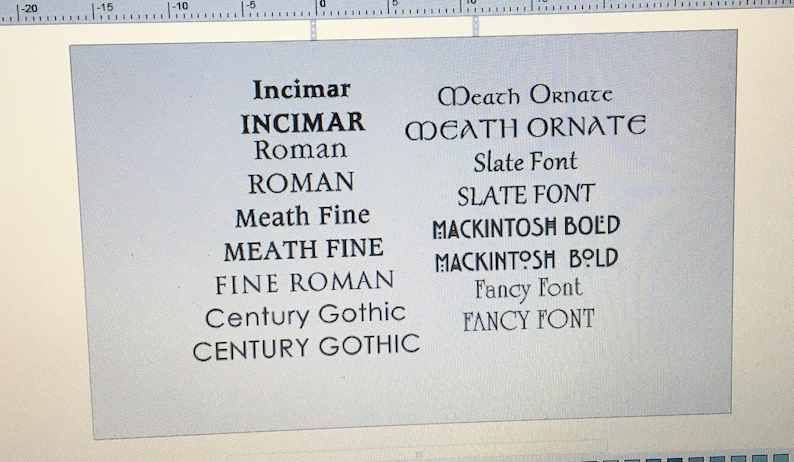 May include: A digital display showing a list of font names in black text on a light gray background. The list includes Incimar, Roman, Meath Fine, Fine Roman, Century Gothic, Meath Ornate, Slate Font, Mackintosh Bold, and Fancy Font in various styles.