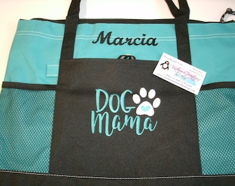 May include: A teal and black tote bag with a mesh pocket. The bag is personalized with the name "Marcia" and the text "Dog Mama" with a white paw print and a heart.