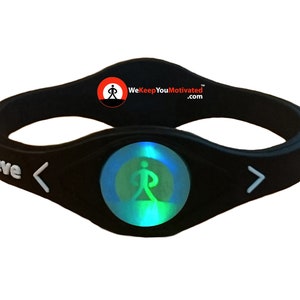 Puede incluir: Pulsera de silicona negra con una inscripción blanca "Believe" y un emblema luminoso verde y azul que representa a una persona caminando. La pulsera también tiene una flecha blanca que apunta hacia la izquierda y la derecha. El texto "WeKeepYouMotivated.com" está impreso en la pulsera.