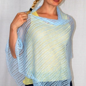 May include: A light blue knitted poncho with a yellow under layer. The poncho has a loose fit and a diagonal striped pattern.