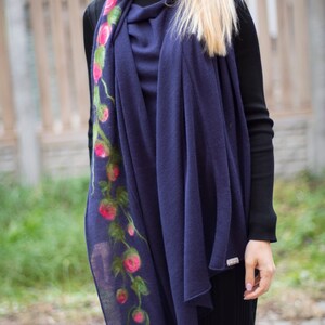 May include: A navy blue scarf with a floral design featuring pink flowers and green leaves. The scarf is made of a soft, lightweight material and is perfect for adding a touch of elegance to any outfit.