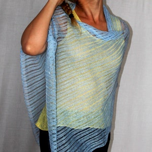 May include: A light blue and yellow striped knit poncho with a loose fit. The poncho is made of a lightweight, airy fabric.