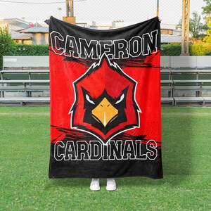 May include: Red and black fleece blanket with a cardinal mascot and the text "Cameron Cardinals".