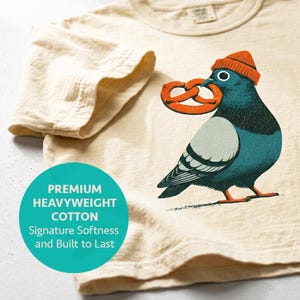 Brooklyn crop in ivory, folded to show the heavyweight Comfort Colors cotton and boxy cut, block print style pigeon design