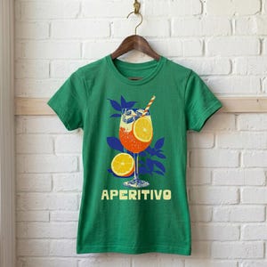 Aperitivo Italian summer tee in Irish green — women's fitted graphic shirt with vintage spritz cocktail design in bold orange and blue, semi-fitted silhouette
