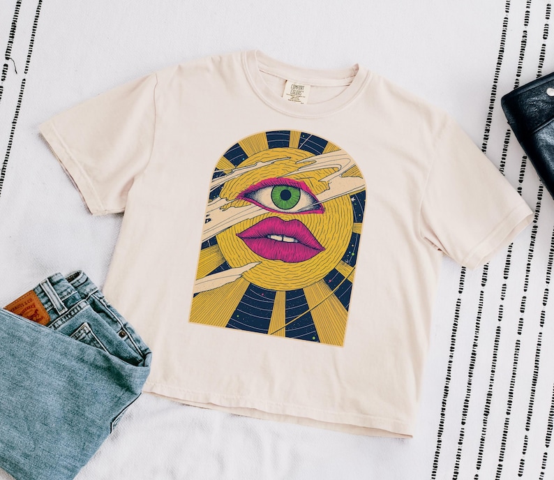 Lay Flat Celestial crop top in ivory Comfort Colors cotton, block print sun face with a third eye surrounded by rays and stars