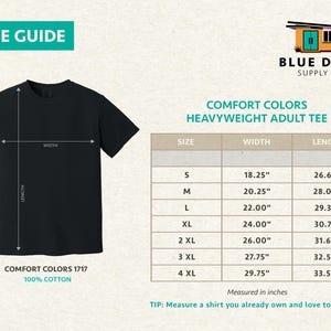 May include: Black t-shirt with a size guide and the text "SIZE GUIDE." The shirt has a size chart with measurements in inches for Comfort Colors Heavyweight Adult Tee. The shirt is 100% cotton.