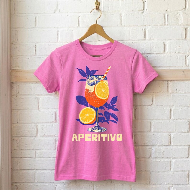 Aperitivo women's fitted graphic tee in pink on hanger — Italian summer spritz cocktail design, semi-fitted silhouette, available in pink, green, and red