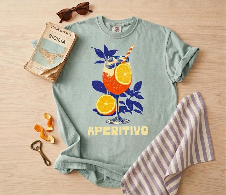 A bay comfort colors tee featuring an italian spritz cocktail and the word Aperitivo below the retro illustrated design.