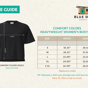 May include: A black boxy t-shirt with a size guide chart for Comfort Colors 3023CL 100% cotton apparel. The chart lists sizes S through 2XL with corresponding width and length measurements in inches, ranging from 18.25 to 26 inches wide.