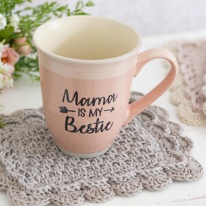Scallop crochet mug rug with coffee cup and flowers.