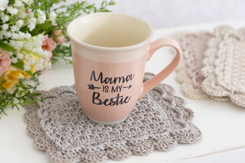 Scallop crochet mug rug with coffee cup and flowers.