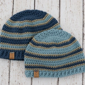 May include: Two striped crocheted hats in blue, teal, and brown with a leather label that says "KHH".