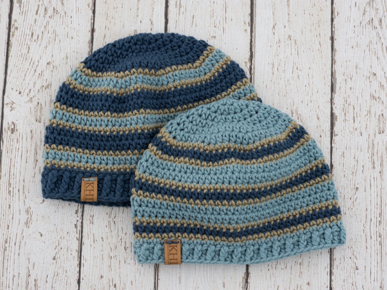 May include: Two striped crocheted hats in blue, teal, and brown with a leather label that says "KHH".