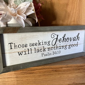 May include: A framed wood sign with a white background and black text. The text reads "Those seeking Jehovah will lack nothing good. Psalm 34:10".